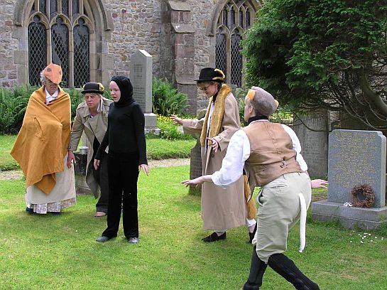 Actors in animal costume in a churchyard